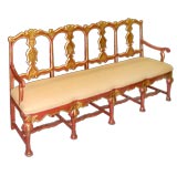 SPANISH BAROQUE CORAL-LACQUERED FOUR-SPLAT LONG HIGH-BACK SETTEE