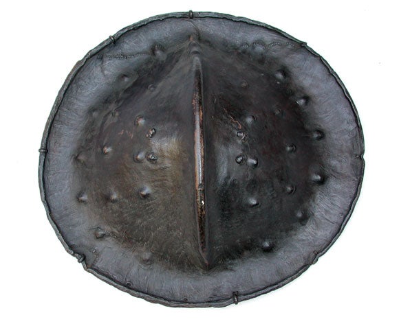 The well-patinated convex circular shield with ribbed middle tapering to a flared edge.
