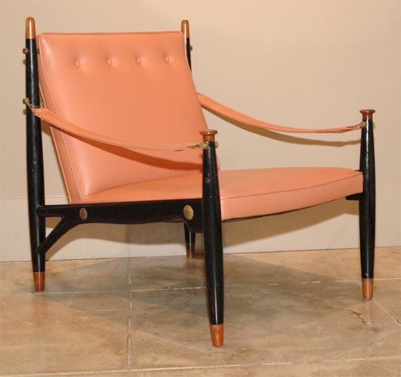 A modernist chair by Frank Kyle. Black lacquered frame with brass Fittings and original melon vinyl upholstery.