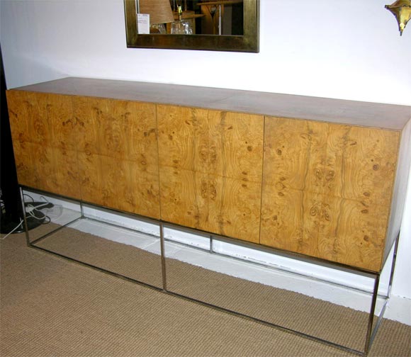 A four door server comprised of a cabinet in book matched olive ash burl veneer, 
