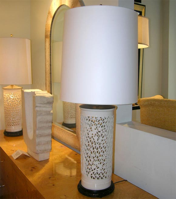 Pair of large Asian porcelain table lamps with perforated flower motif on hand-carved ebonized wooden bases with internal illumination, American 1950's