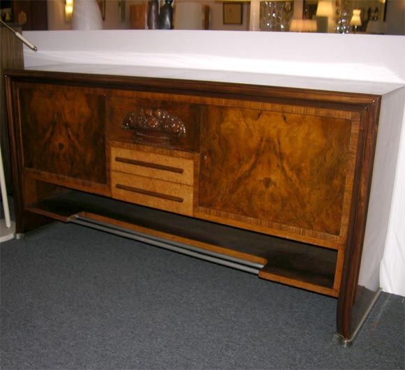 Dassi art deco buffet made in Milan 1935, rosewood and walnut burl, carved center panel
of fruits and flowers. Chrome bar on base and chrome trim on legs,two drawers and two large storage areas on left and right each with one shelf.