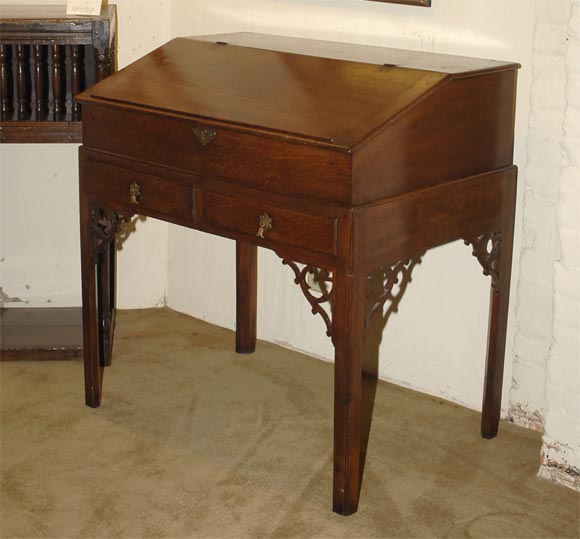Queen Anne oak lift-top secretaire-desk with two drawers and intricate fretwork.