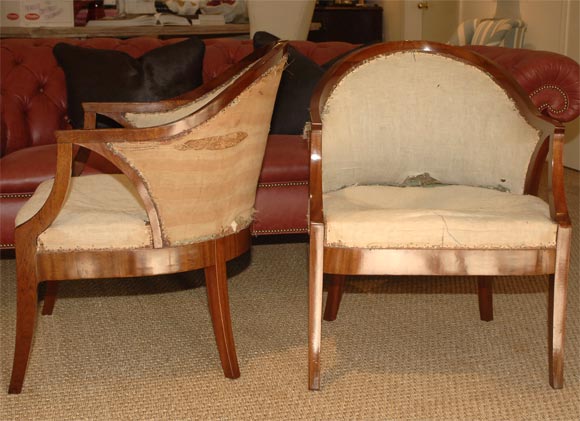 Beautiful pair of Empire, late 19th Century tub chairs<br />
in lush mahogany finish<br />
horseshoe shaped back terminating to<br />
rectangular seat with down swept arm supports <br />
a predecessor to the deco chairs of <br />
the early 19th