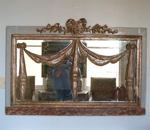 Painted and parcel gilt mirror with silver gilt accents.