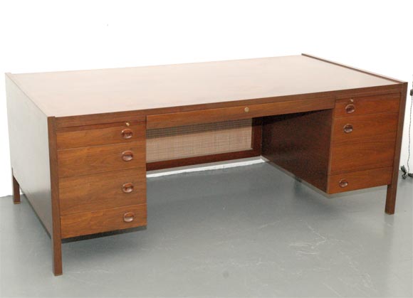 Executive style Dunbar desk with caned modesty panel and brass feet.  Professionally refinished with rosewood pulls.