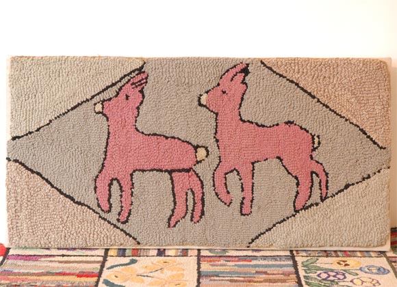 WONDERFUL AND FOLKY PICTORIAL HAND HOOKED/MOUNTED RUG OF A PAIR OF DEER.THIS RUG IS FROM PENNSYLVANIA.THE DEER ARE A DUSTY ROSE COLOR AND ARE ON A BEIGE GROUND AND OUT LINED IN BLACK.THE CONDITION OF THE RUG IS PRISTINE AND VIBRANT IN COLOR.