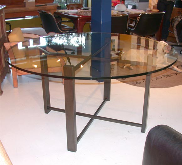 Custom made folding x base in stainless or patinated steel.   Glass top is  to order