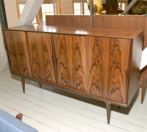 Handsome figured rosewood sideboard, mid-20th century Danish modern. Sliding doors, one set of sliding trays, cupboards with shelves.