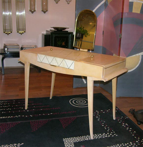 A sycamore, gilt bronze and parchment vanity with mirror by Maxime Old (1910-1991,) created, circa 1940. Only three examples of this design have ever been produced, this being the only one where parchment is used instead of black leather. 

Ref.