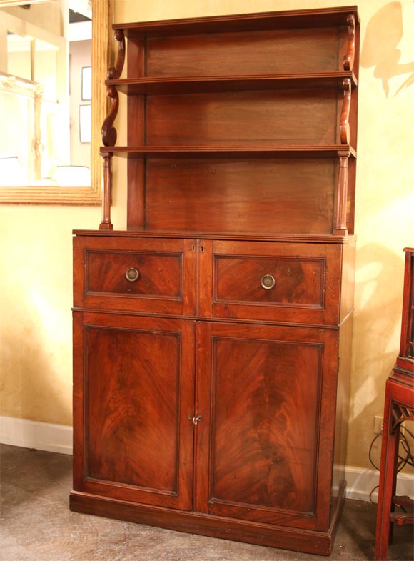 Handsome English George III flame mahogany butlers desk, graduated shelves over fall front desk over pair of doors opening to shelving with one wine drawer.  Very usefull piece of furniture, perfect computer center to stow away laptop and printer