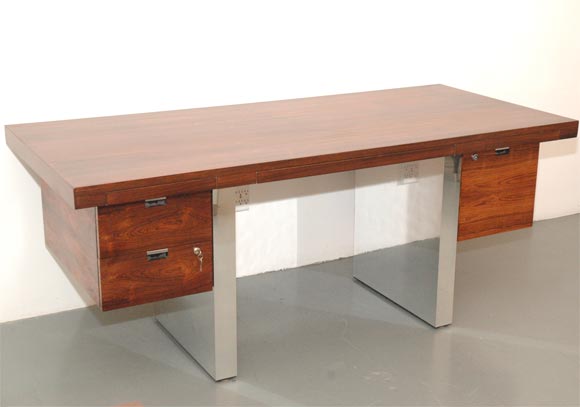 Beautiful rosewood chrome desk designed by Roger Sprunger for Dunbar.  Desk has chrome panel legs with cantilevered desk drawers.  Professionally refinished with beautiful grain to rosewood.