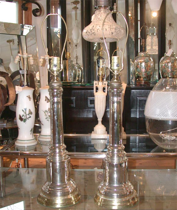 Pair of slender column lamps in mercury glass with brass detailing and base - measured to socket on a 7.5 inch diameter base.