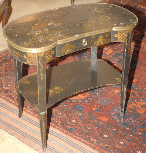 Louis XV gilt-metal mounted parcel-gilt chinoiserie-decorated black lacquer table a rognon, the kidney shaped top above a central frieze drawer, raised on hipped legs joined by a shaped shelf.