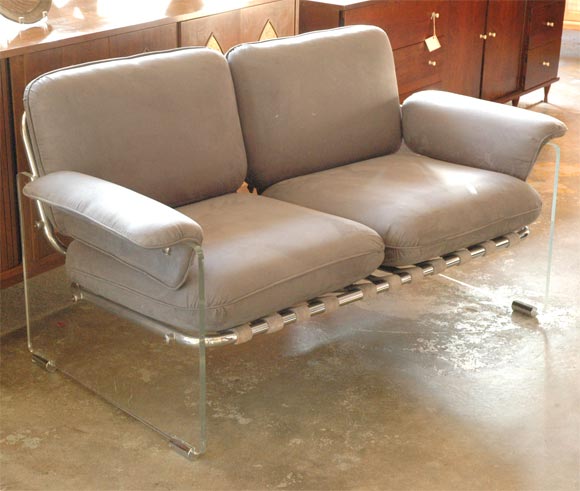 lucite sides and chromed tubular frame settee.Leather straps support the back cushions which are covered with grey ultrasuede.