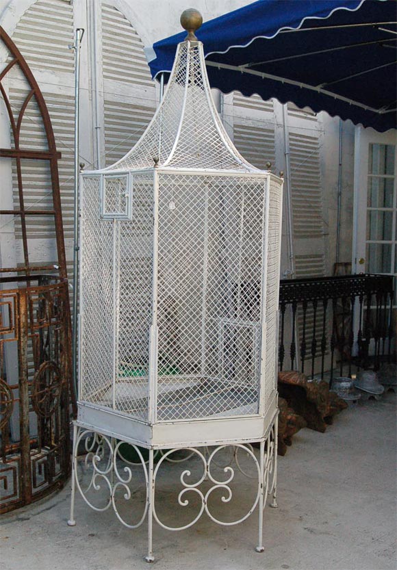 Heavy wire mesh cage in iron frame,with large brass ball finial on top and smaller ones on each corner,slide out tray on wrought iron base