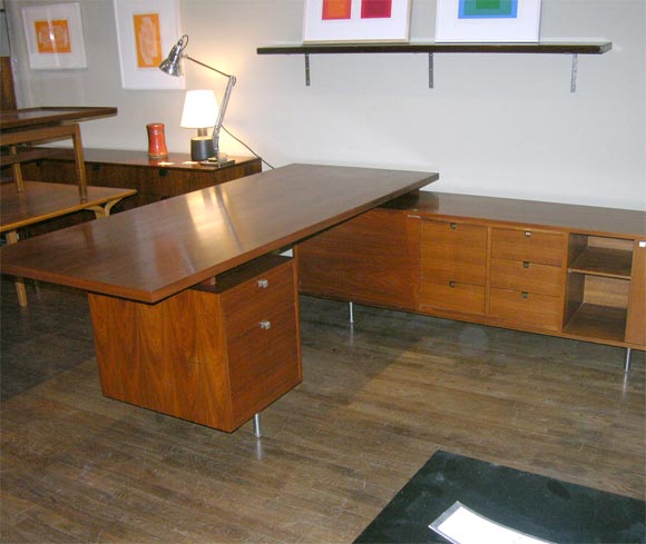 George Nelson L shaped walnut executive desk on tubular aluminum legs with rattan or solid wood privacy panels (not shown here).  Table top depth is 36