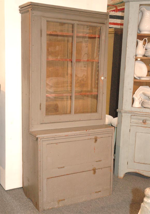 19THC FOLKY STEPBACK CUPBOARD ORIGINAL GREY OVER RED PAINT.FOUND IN PENNSYLVANIA.THIS CUPBOARD IS VERY UNUSUAL FORM AS THE DOOR OPENS FROM RIGHT TO LEFT AND THE DOORS BELOW OPEN FROM TOP TO BOTTOM,INSTEAD OF SIDE TO SIDE. THIS CUPBOARD WAS PROBABLY