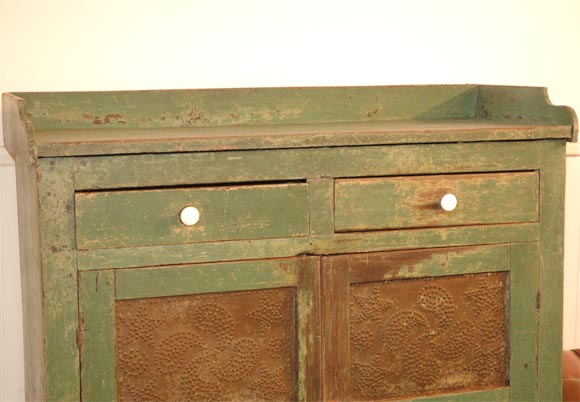 19THC ORIGINAL GREEN PAINTED PIE SAFE FROM PENNSYLVANIA WITH ORIGINAL PUNCHED TINS WITH FLYFOOT AND STARS DESIGN IN THE TINS AND ALL ORIGINAL HARDWARE.WONDERFUL ORIGINAL BACK SPLASH AND GREAT CUTOUT FEET.GREAT ORIGINAL PUTTY COLOR INTERIOR IN