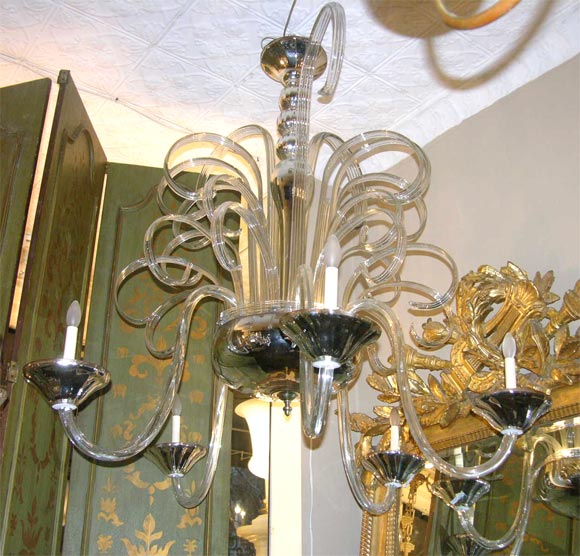A pair of large blown glass Murano chandeliers, with five arms and eight lights in body.
With oversized blown glass applied decorations. Mercury glass body and bobeches.
Sold separately.