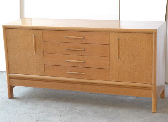 Modernist blonde wood (bleached ribbon mahogany)sideboard manufactured by Brown Saltman. Features adjustable shelves, four drawers(one fitted for flatware,)and secret bottom compartment for table leaves.