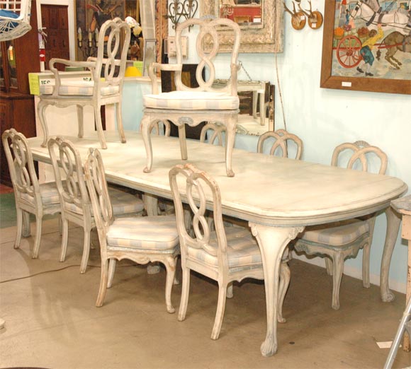 This set matches the Gustavian style cabinet I have listed. This is a 10 foot rounded end painted wood table with cabriolet legs. The table does not fold smaller. There are 10 chairs--2 arm chairs and 8 regular chairs. The chairs have cane seats,