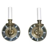 a pair of mirrored sconces with brass brackets