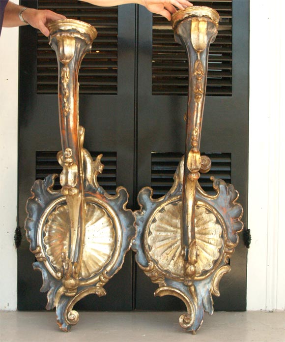 Pair of exceptional and large-scale wall sconces. Two pair are available. These are truly pairs as each faces the other.