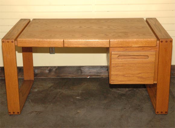 An oak executive desk by Lou Hodges of the San Diego design group, with open frame construction legs, pencil drawer, and single file drawer.