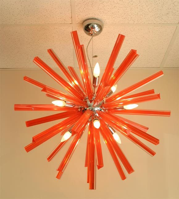Unusual Sputnik chandelier made of 40 pieces of glass.<br />
Each pieces has 2 layers: the first, internal one in orange and the second, external one in transparent glass.<br />
2 available.<br />
Triangular section<br />
Substained by a thin