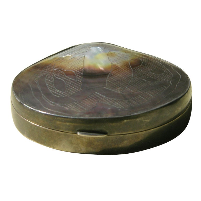 Powder compact in silvered bronze with incised mother-of-pearl top. Signed.
