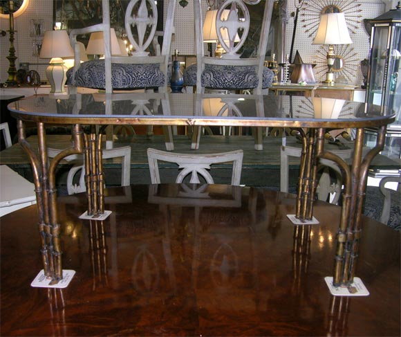Iron faux bamboo coffee table with gilt finish and bronze mirror top. Oval in shape. Mirror cut from old stock.