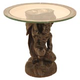 A Glass and Mirrored Top Table with Carved Wood Cherub Base