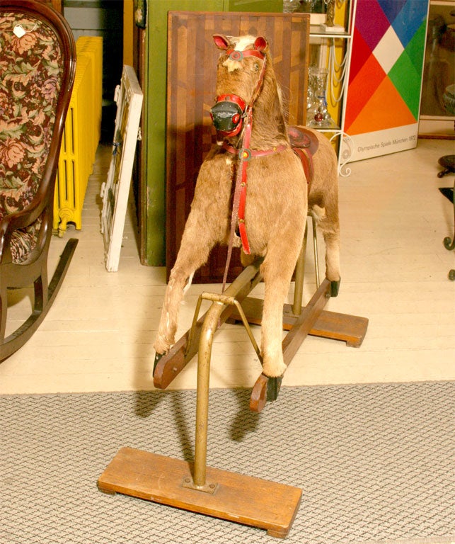 Wooden hide covered rocking horse with bridle and saddle.