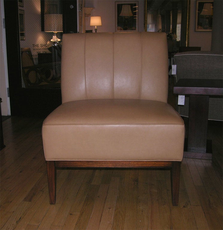 Comfortable channel back chair upholstered in taupe leather with tapered wooden legs.  Designed by Mariette Himes Gomez for Hickory Chair.