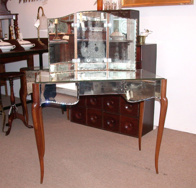 Art Deco Vanity with Two Drawers on either Side and Trifold Mirror and Thumbprint Edge.Warm Walnut Legs.Image 5 best represents the condition of the Mirror overall.Some Silvering.