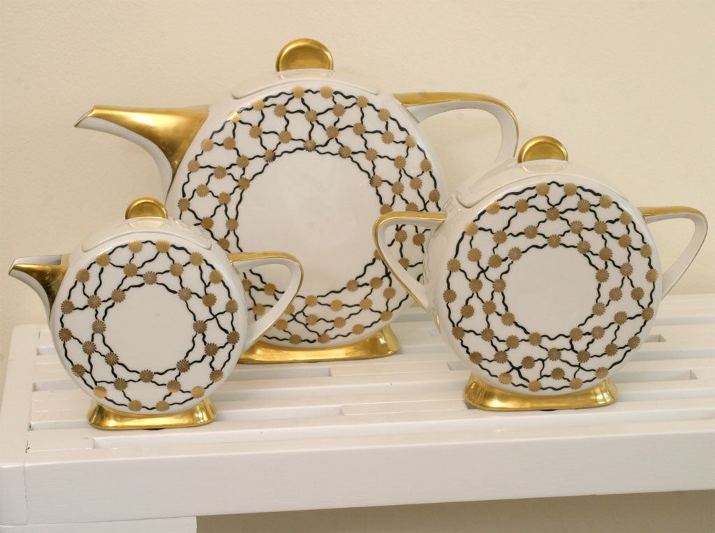 Three piece set by Limoge with gold leaf on bases, spouts, and tops. This set is in mint condition and probably never used. Please call for more dimensions.