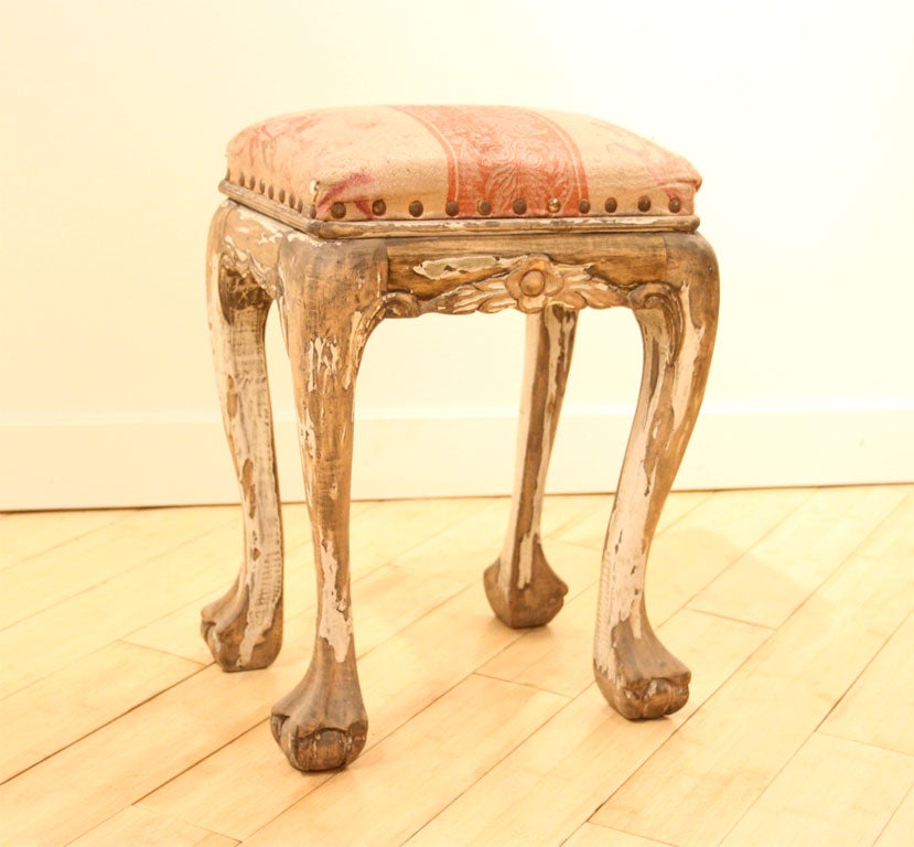 Small stool with floral carving, and ball and claw feet from the port city of Tianjin, China commissioned by a European expatriate in a European furniture stlye.  Stool retains some original paint, and appears to be original upholstery.