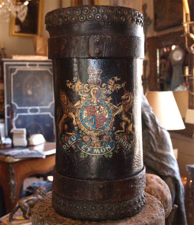 The leather fire water bucket has two lions holding a crest.  The French moto reads HONI SOIT QUI MAL Y PENSE and DIEU ET MON DROIT.  The leather bands are studded with patinated brass tacks.  The handle is also made of leather.  The colors are very