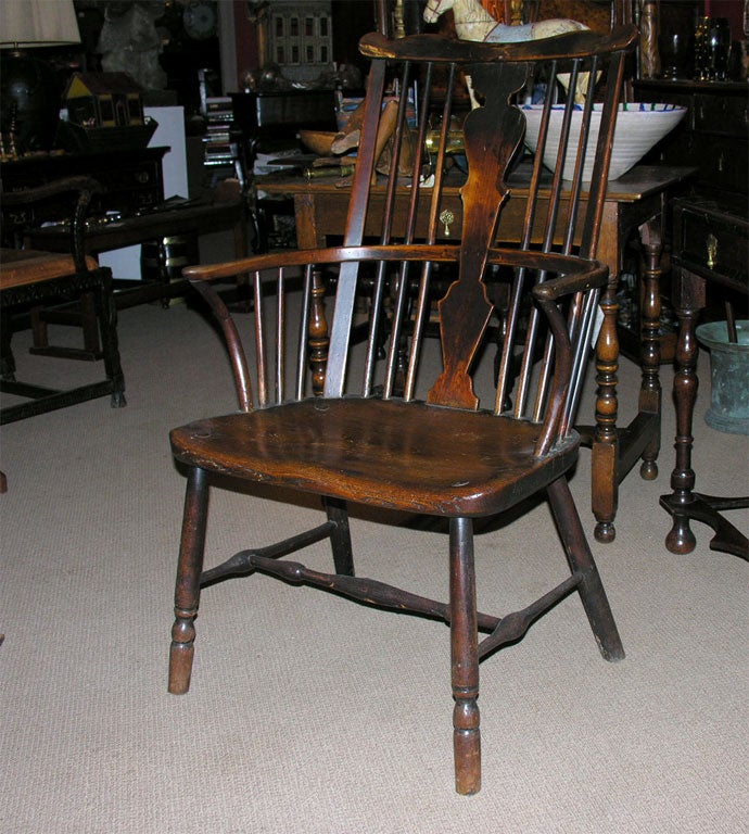 An 18th century Thames Valley fruitwood and elm Windsor armchair having a boldly shaped crest, beautifully shaped center backsplat, and nicely saddled seat on turned legs. It has wonderful patina and color and generous scale and proportions.
