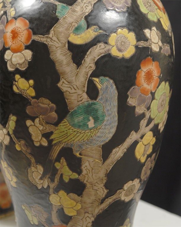 A pair of Chinoiserie vases with floral and bird motifs set on a black ground; white glazing on the inside and the bottom; markings on the bottom; excellent condition