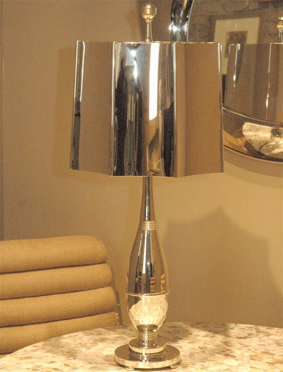 Lamp base and shade in polished nickel.