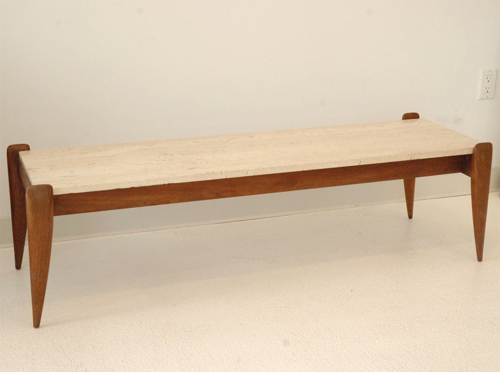 A chic walnut and travertine cocktail table designed by Gio Ponti, manufactured by Singer and Sons.  Walnut retains original oiled finish, and the original label is attached on the underside.