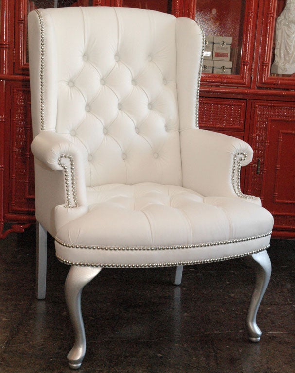 Pair of wonderful and petite wingback chairs with silver legs and chrome nailheads. Covered in white pig-skin textured vinyl.