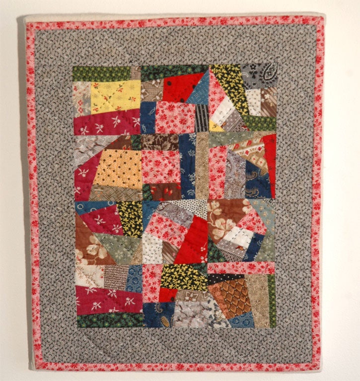 CONTEMPORARY SMALL CRAZY DOLL QUILT .MOUNTED ON HOMSPUN LINEN ON A STRETCHER FRAME.