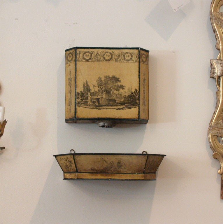 Small, wall mounted tole fountain in two pieces with decorative painted neo-classic upper boarder designs and central landscape scenes.  The upper piece is 11