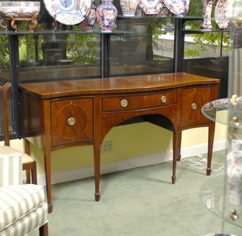 An early 19th century Mahogany Inlaid George III Period Mahogany Inlaid Serpentine Sideboard with cellarette drawer