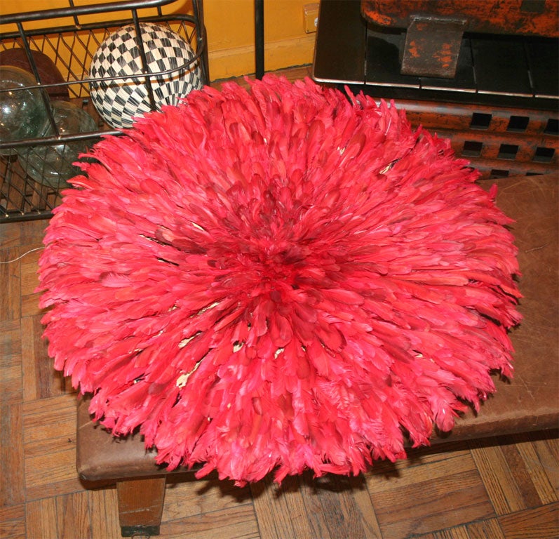 Ceremonial hat worn in fertility dance. Red dyed feathers with dark black feathered hat structure.