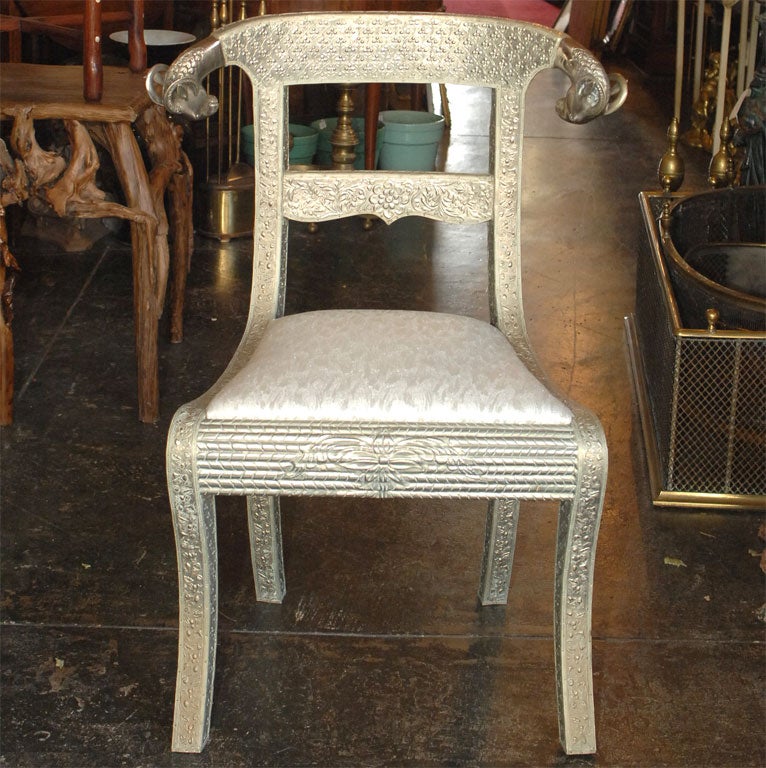 Wooden Regency-style chairs completely clad with elaborately embossed tin.