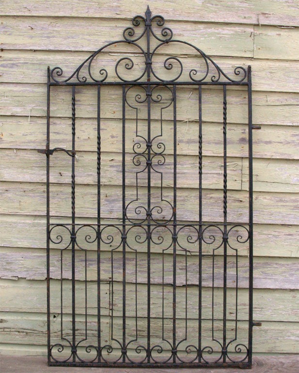 Single iron gate with scrolling details and latch.